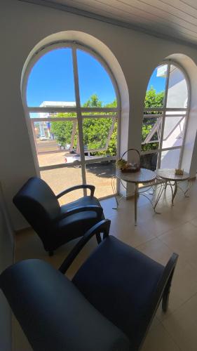 a living room with a chair and a large window at Hotel LENA in São Luiz Gonzaga