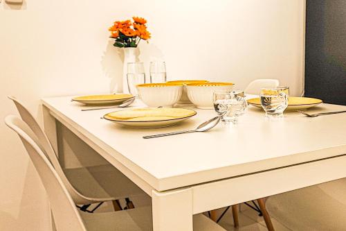 a white table with yellow plates and glasses on it at Luxury Pool at M-Luna by HCK in Kuala Lumpur