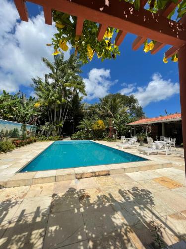 Una piscina en un patio con sillas y árboles. en acomodações hilton 100, en Ipueiras