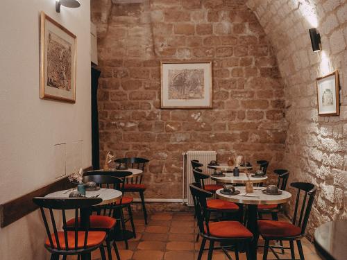 une salle à manger avec des tables et des chaises dans un mur en briques dans l'établissement Hôtel Belloy Saint Germain, à Paris