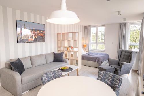 a living room with a couch and a chair at Chrobry Apartamenty Gdańsk Grodzka 10 in Gdańsk