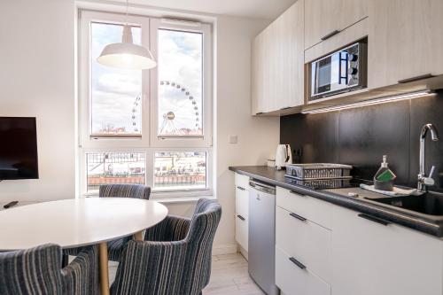 a kitchen with a table and chairs and a ferris wheel at Chrobry Apartamenty Gdańsk Grodzka 10 in Gdańsk