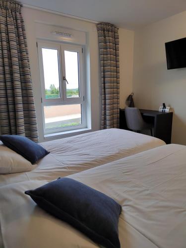 a bedroom with two beds and a window at Relais Saint Michel in Saint-Michel