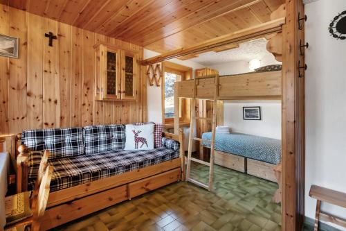 a log cabin bedroom with a couch and a bed at Nido Alpino Terme e Sport - Bormio in Valdidentro