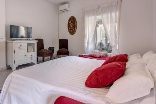 a bedroom with a large white bed with red pillows at La Torretta by Comorooms in Como