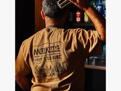 a man is holding a drink in a bar at Trailborn Grand Canyon, Outdoor Collection by Marriott Bonvoy in Williams