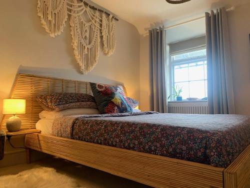 a bedroom with a large bed and a window at Dolgellau Townhouse 2 Minutes to Town & Mountains in Dolgellau