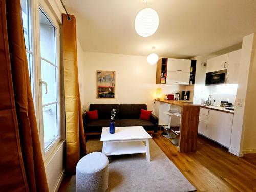 un petit salon avec un canapé et une table dans l'établissement Agréable appartement en centre-ville, à Angoulême