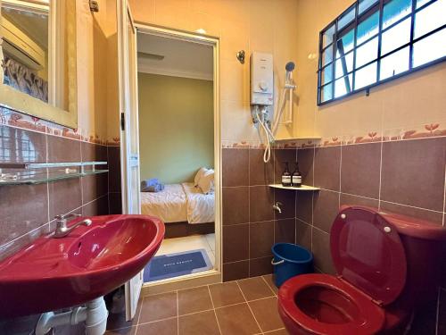 ein Badezimmer mit einer roten Toilette und einem Waschbecken in der Unterkunft Kota Laksamana 2-Strey Walk to Jonker Street in Malakka