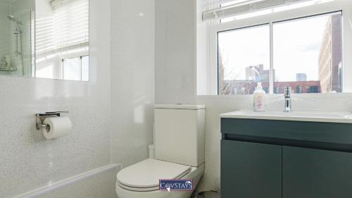 a bathroom with a toilet and a sink and a window at Old Silk Apartments - Luxury Studios, 1 & 2-beds in Coventry City Centre by COVSTAYS in Coventry