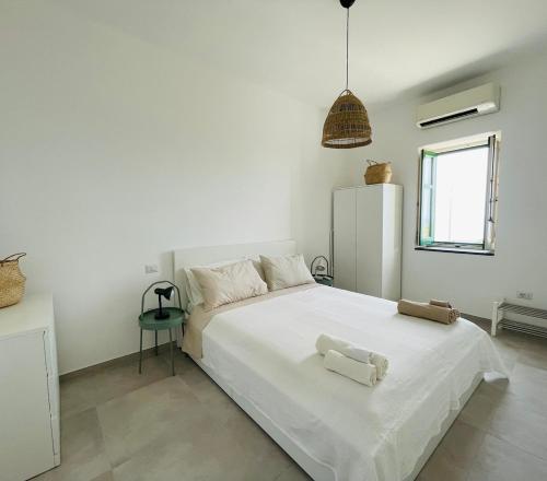 a bedroom with a white bed with two towels on it at Arco sul Mare Malfa - Le Case di Valeria & Matteo in Malfa