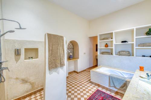 une salle de bain avec baignoire dans une chambre dans l'établissement Palais Noryalis, à Tillouna