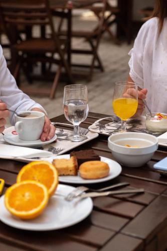a table with plates of food and glasses of orange juice at U-Sense For You Hostel Sevilla in Seville
