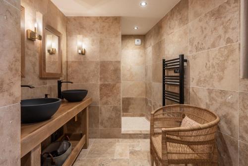 a bathroom with two sinks and a walk in shower at Le Cellier & Spa in Saint-Maximin