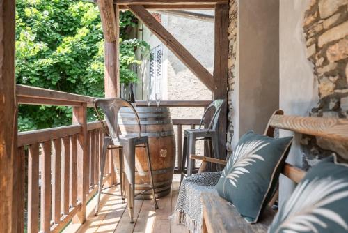 - une terrasse couverte avec des chaises, une table et un tonneau dans l'établissement Le Cellier & Spa, à Saint-Maximin