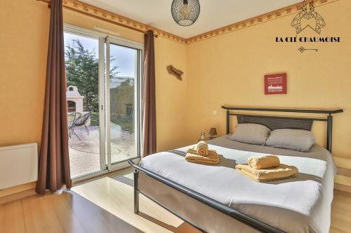 una camera da letto con un letto e una grande finestra di Villa LS - Agreable Villa avec piscine et jacuzzi a Les Sables-dʼOlonne