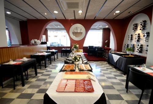 a dining room with tables and chairs in a restaurant at Hotel Spa Pinar del Mar in Platja  d'Aro