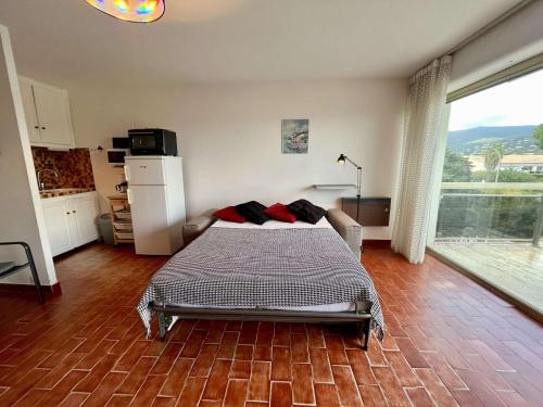 une chambre avec un lit et une grande fenêtre dans l'établissement Studio face mer avec terrasse, clim, parking à Cavalaire-sur-Mer - FR-1-226B-13, à Cavalaire-sur-Mer