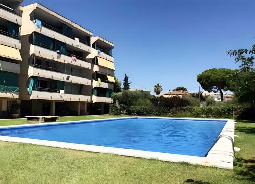 a swimming pool in front of a apartment building at Apartamento Francás in Comarruga