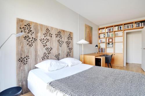 une chambre avec un lit blanc et un mur en bois dans l'établissement Exceptionnel 3P 100m2 - luxe & lumière face parc Monceau, à Paris