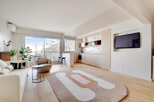 un salon avec un canapé et une télévision dans l'établissement Exceptionnel 3P 100m2 - luxe & lumière face parc Monceau, à Paris