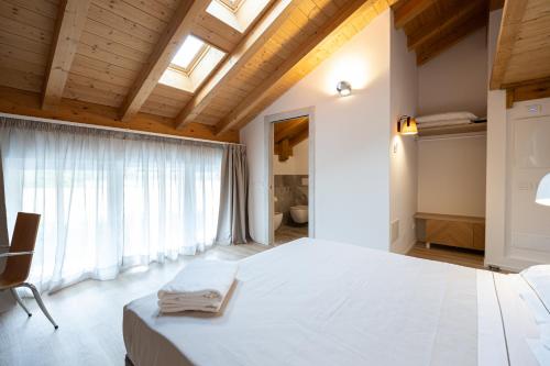 a bedroom with a large white bed and a window at Agriturismo Sadira in Calusco dʼAdda