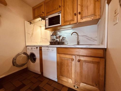 une cuisine avec des armoires en bois et une laveuse et une sécheuse dans l'établissement Charmant T2 mezzanine 5 pers, balcon sud, proche centre et pistes, parking privé - Le Monêtier les Bains - FR-1-330F-158, au Monêtier-les-Bains
