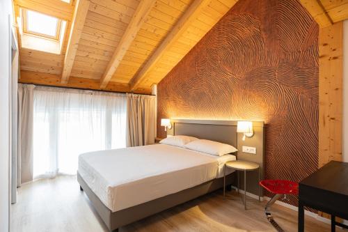 a bedroom with a bed and a wooden wall at Agriturismo Sadira in Calusco dʼAdda