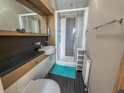 a bathroom with a toilet and a sink and a shower at Beautiful 6 Berth Caravan With Decking At Dovercourt Park, Essex Ref 44009G in Great Oakley