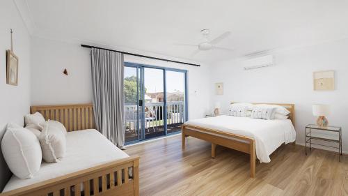 Un dormitorio con dos camas y una ventana. en Coastal Hideaway - Water Views and Walk To The Beach, en Corlette