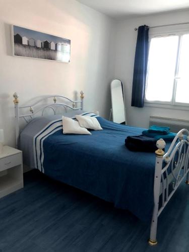 une chambre avec un lit avec une couette bleue dans l'établissement Bas de Villa avec piscine, à Linguizzetta