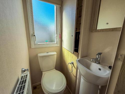 a small bathroom with a toilet and a sink at Lovley 8 Berth Caravan At Dovercourt Park, Essex Ref 44202B in Great Oakley