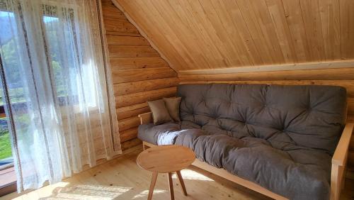 a living room with a couch and a chair at Котеджі Карпати Fest in Mizhhirʼʼya