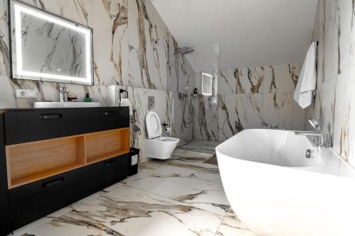 a bathroom with a tub and a sink and a toilet at Elysium House in Truskavets