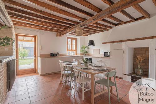 une cuisine avec une table et des chaises dans une pièce dans l'établissement Un Rêve Bleu d'Aladin - Escale à Disneyland Paris, à Magny-le-Hongre