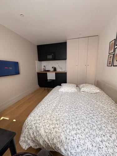 une chambre avec un grand lit et une cuisine dans l'établissement Studio Heliopolis - Best Location, à Paris