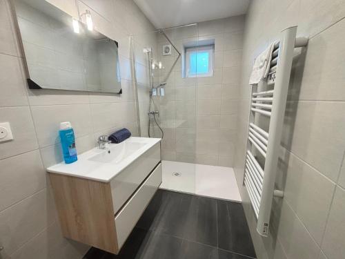a white bathroom with a sink and a shower at Maréchal 1 Parking 4 Couchages in Clouange