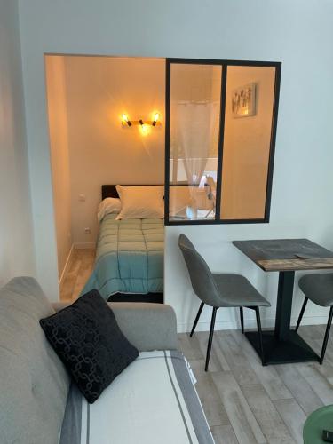 a room with a bed and a table and a mirror at Studio coin nuit terrasse parking Clim in Nice