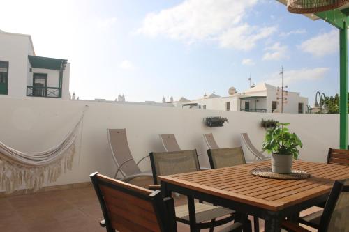 a wooden table and chairs on a balcony at Vivilanza Surfhouse in Costa Teguise