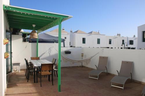 a patio with a table and chairs on a balcony at Vivilanza Surfhouse in Costa Teguise