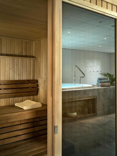une salle de bain avec une baignoire et un lavabo dans l'établissement Best Western Hôtel De La Cité & Spa, à Guérande