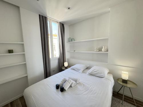 une chambre blanche avec un lit avec des serviettes dessus dans l'établissement charmante suite vue mer villa Carmela, à Cannes