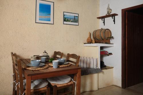 a dining room table with chairs and a barrel at theVotsalo Eco house in Agios Padeleimon