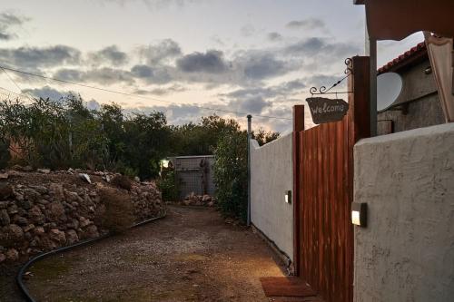 a gate to a house with a stone wall at theVotsalo Eco house in Agios Padeleimon