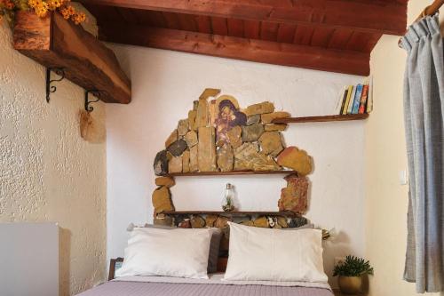 a bedroom with a stone wall above a bed at theVotsalo Eco house in Agios Padeleimon