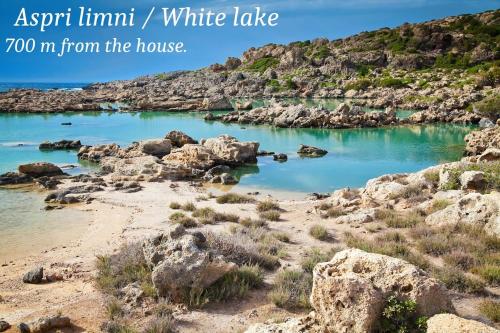 a view of a beach with blue water and rocks at theVotsalo Eco house in Agios Padeleimon