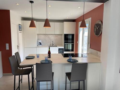 - une cuisine avec une table et des chaises ainsi qu'une bouteille de vin dans l'établissement Maison 3 chambres 