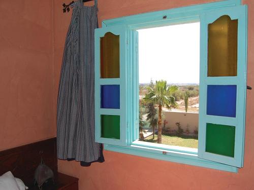 a window in a room with a view of a palm tree at Gite Souss in Oulad Teima