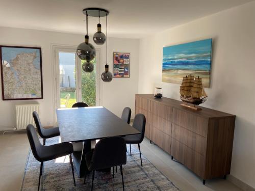 une salle à manger avec une table et des chaises dans l'établissement Maison 3 chambres 