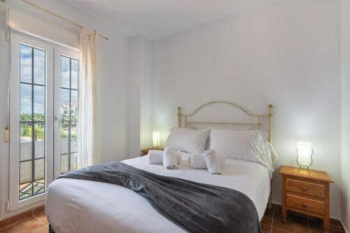 a bedroom with a large white bed and a window at Playa Grande - Playa Punta del Moral PPHG88P84 in Punta del moral